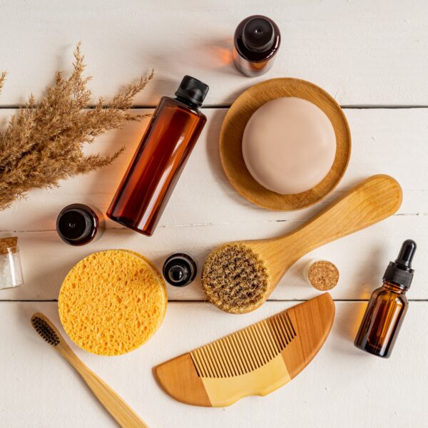 Top view of skin and body care treatment products. Face brush, comb, essential oil, sponges